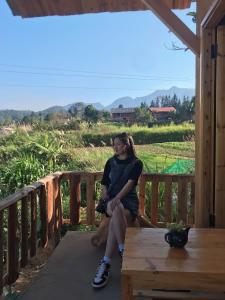 een vrouw die op de veranda van een huis zit bij Dồn Dao Homestay in Ha Giang +107 foto's