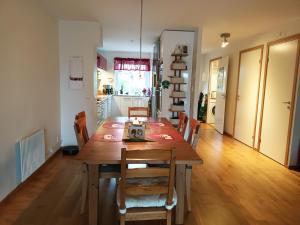a kitchen and dining room with a wooden table and chairs at Nice house near the center of Ängelholm in Ängelholm
