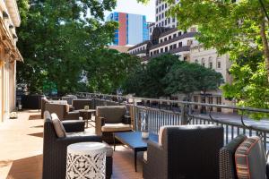 una fila de sillas y mesas en un balcón en The Stephen F Austin Royal Sonesta Hotel, en Austin