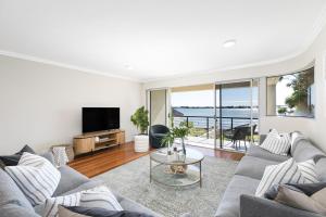 un soggiorno con divano e TV di Panoramic Water View Apartment a Sylvania
