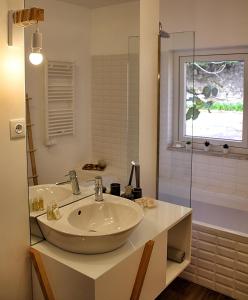 W łazience znajduje się umywalka i przeszklony prysznic. w obiekcie Casas de Alpedrinha w mieście Alpedrinha