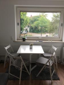 a table and two chairs in front of a window at DeichApartments70-78 in Bremerhaven
