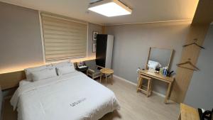 Un pat sau paturi într-o cameră la Tongyeong Chosun Hotel