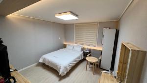 Un pat sau paturi într-o cameră la Tongyeong Chosun Hotel