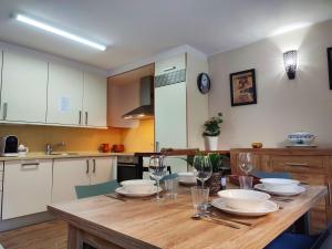 a kitchen with a wooden table with dishes on it at AC Apartaments Bordes in Bordes d´Envalira 
