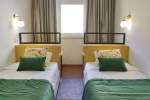 two beds in a room with green and white at Casas de Alpedrinha in Alpedrinha