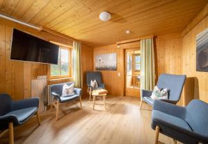a living room with chairs and a flat screen tv at Apartmenthaus Matri in Wald am Arlberg