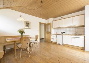 a kitchen with a table and chairs in a room at Enzian, Obertörgglerhof in Brixen