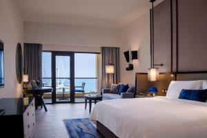 ein Hotelzimmer mit einem Bett und Meerblick in der Unterkunft Amwaj Rotana, Jumeirah Beach - Dubai in Dubai