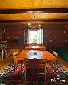 a dining room with a wooden table and chairs at Vila Tornik in Zlatibor