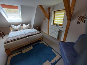 ein Schlafzimmer mit einem Bett und einem Stuhl und einem Fenster in der Unterkunft Ferienwohnung Morgensonne Kurort Rathen in Rathen