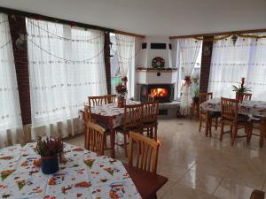 a dining room with tables and chairs and a fireplace at Belvedere La Cristina in Corbeni