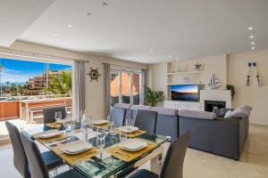 ソトグランデにあるLuxury Penhouse, Sotogrande Marina - Located in an exclusive island of the Marinaのテーブルと椅子のあるダイニングルームとリビングルーム