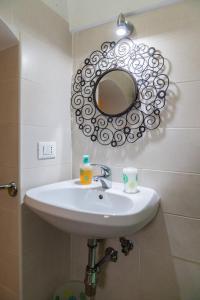 Casa Lucrezia في أوستوني: حوض الحمام مع مرآة على الحائط