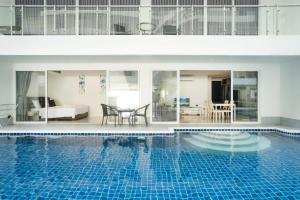 a house with a swimming pool with a bedroom and a table at sunset plaza condominium by Ryan, 600 meters to Karon Beach in Karon Beach