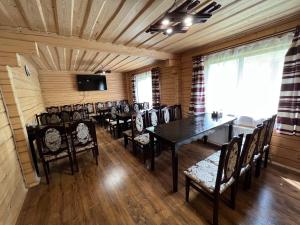 a room with a dining room with a table and chairs at Котедж Mezohat in KozÊ¼meshchek