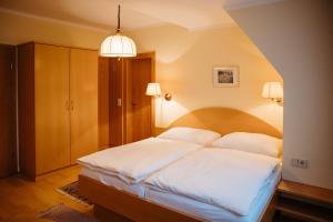 - une chambre avec un grand lit et des draps blancs dans l'établissement Gasthof Schattleitner, à Brückl