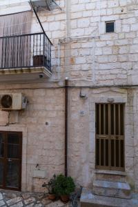 um edifício de tijolos com uma porta e uma varanda em Casa Lucrezia em Ostuni