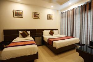 Habitación de hotel con 2 camas y ventana en Hotel Maya 'NEW DELHI', en Nueva Delhi