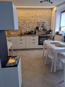 a kitchen with a white table and white cabinets at Casa Santini in Jáchymov