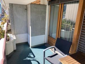 d'un balcon avec une chaise et une porte en verre. dans l'établissement Lovely 1-bedroom apartment in the heart of Davos, à Davos