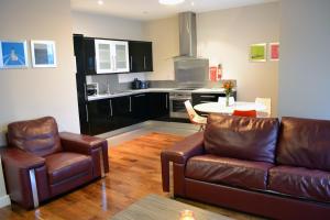 a living room with a couch and a table and a kitchen at Carrick Plaza Suites and Apartments in Carrick on Shannon