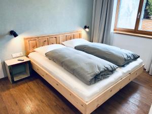 łóżko z dwiema poduszkami w sypialni w obiekcie Das Stubai - exklusiv, einzigartig & nachhaltig w mieście Fulpmes