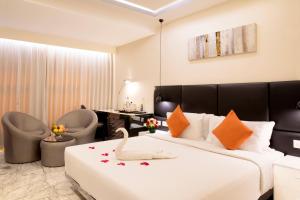 sypialnia z dużym białym łóżkiem z pomarańczowymi poduszkami w obiekcie CJ Pallazzio,Salem w mieście Selam