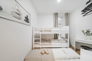 a small white bedroom with bunk beds in it at Central City Rooms by HOME2 in Vienna