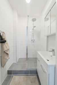 y baño blanco con lavabo y ducha. en Central City Rooms by HOME2 en Viena