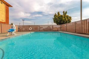 a swimming pool in front of a wooden fence at Super 8 by Wyndham The Dalles OR in The Dalles