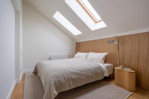 a bedroom with a bed and a skylight at Bright Designer Apartment In City Centre in Rīga