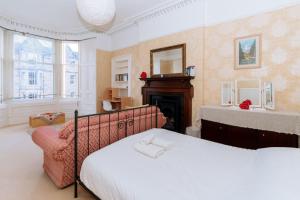 a bedroom with a bed and a fireplace at Spacious 4 Bedroom Apartment Near The MeadowsOld Town in Edinburgh