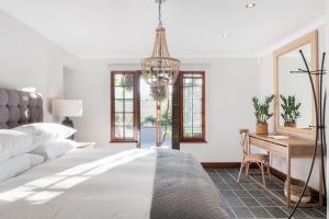 Habitación blanca con cama y escritorio en Avemore Time Out - with Backup Power, en Stellenbosch