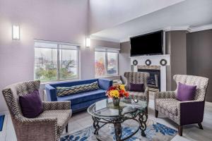 sala de estar con sofá azul y sillas en Baymont by Wyndham Gurnee, en Gurnee