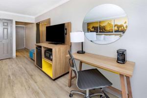 Habitación con escritorio y espejo. en Days Inn by Wyndham Del Rio, en Del Rio