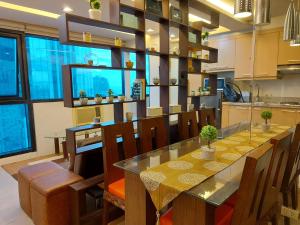 a kitchen with a dining room table with chairs at Comfy Bunkbed with Pool in Manila