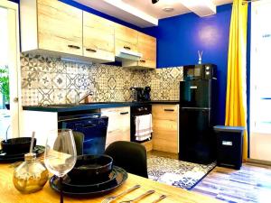 a kitchen with a table and a black refrigerator at Le Black and Wood, proche centre, parking gratuit. in Sens