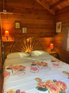 CHALET ETNA MILO في ميلو: غرفة نوم بها سرير عليه زهور