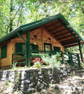 a log cabin with a stone wall in front of it at CHALET ETNA MILO in Milo