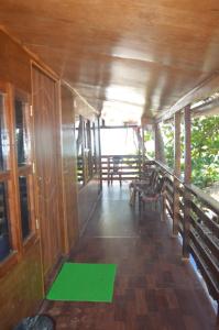 una habitación con sillas y una alfombra verde en un porche en Soulmate Beach Resort, en Agonda