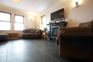 a living room with a couch and a fireplace at Wesdale, Stromness - 3 Bedroom Holiday Cottage in Orkney