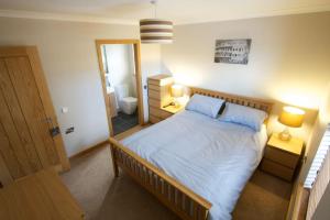 a bedroom with a large bed and a bathroom at Wesdale, Stromness - 3 Bedroom Holiday Cottage in Orkney