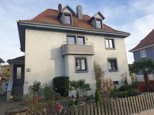 a white house with a fence in front of it at Ferienwohnung Müller in Kenzingen