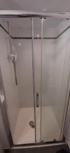 een douche met een glazen deur in de badkamer bij Scotch Street in Dungannon