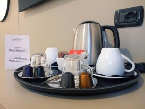 a tray with plates and cups on a table at BB Hotels Smarthotel Derose in Florence
