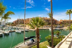 ソトグランデにあるLuxury Penhouse, Sotogrande Marina - Located in an exclusive island of the Marinaの船やヤシの木や建物のあるマリーナ