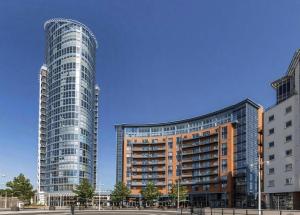 two tall buildings in a city with a blue sky at Luxury 3 Bedroom 3 Bathroom Balcony Apartment - Gunwharf Quays Apartments in Portsmouth
