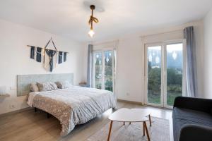 a bedroom with a bed and a couch and windows at Casita Rural La Piñera in Los Realejos