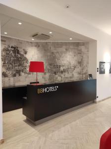 una lampada rossa seduta sopra una reception di BB Hotels Smarthotel Derose a Firenze